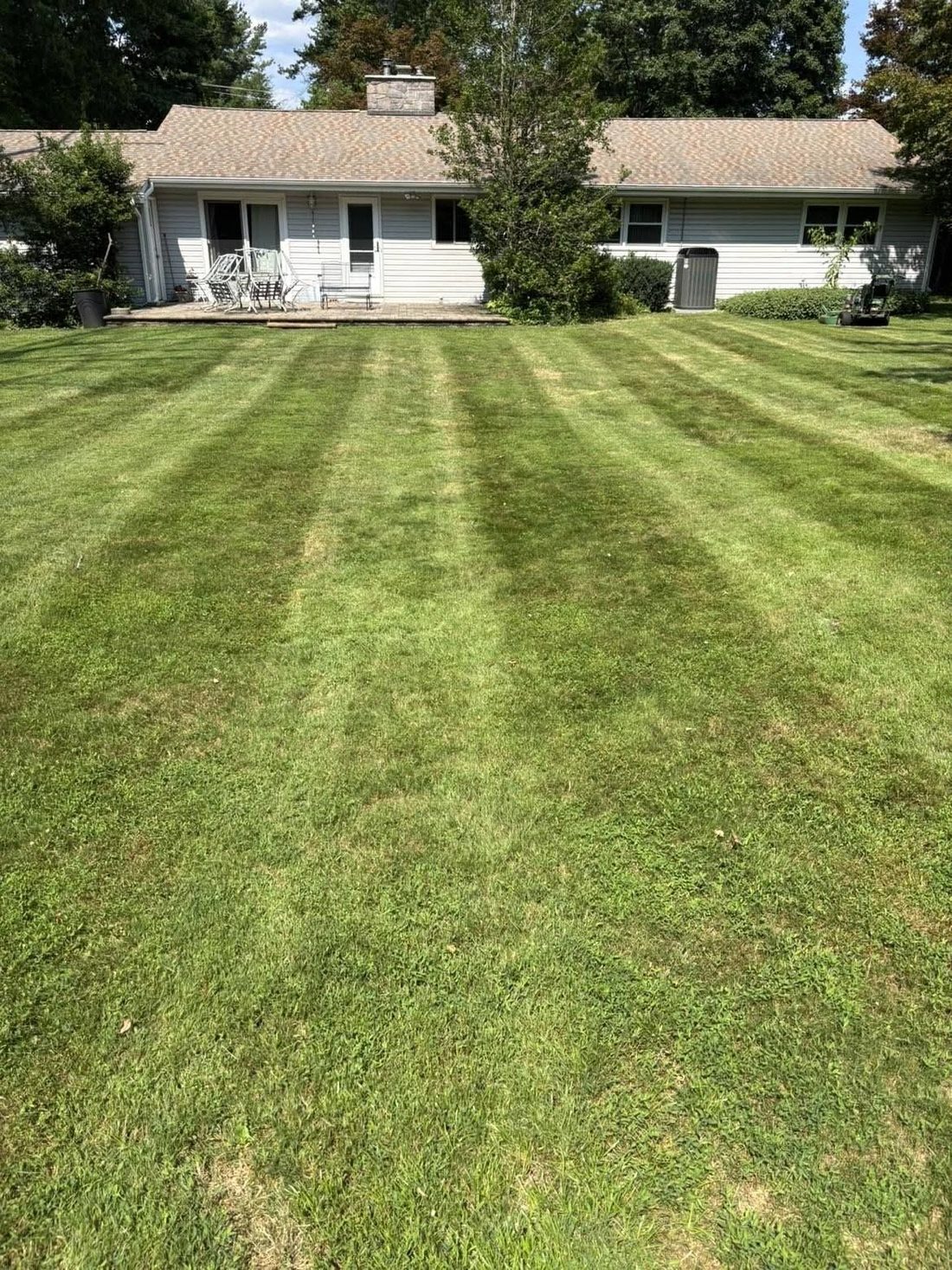 Backyard of a ranch home mowed in parallel stripes